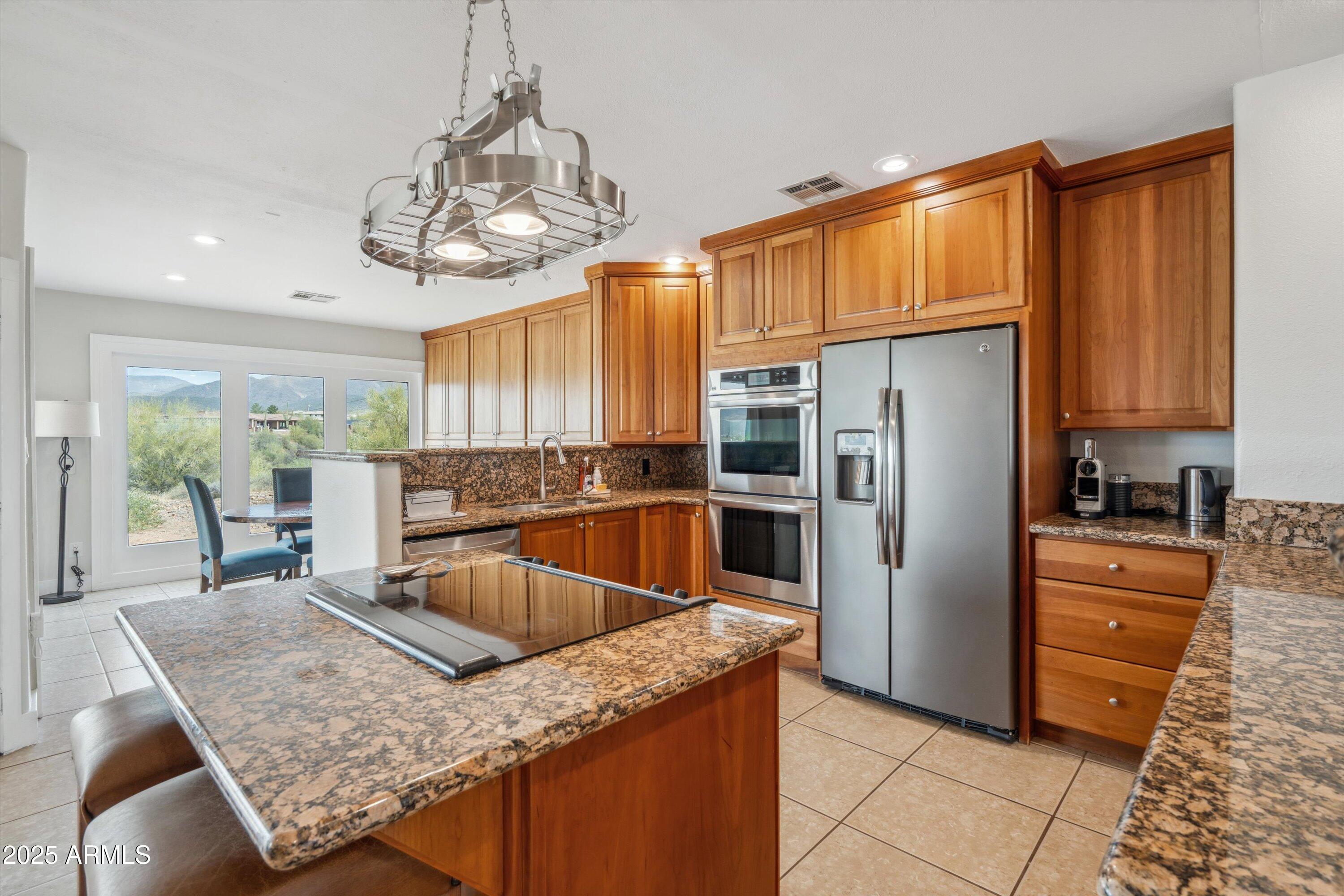 7080 East Arroyo Road Cave Creek, AZ 85331 - Photo 14 of 50 a kitchen with stainless steel appliances granite countertop a sink refrigerator and cabinets