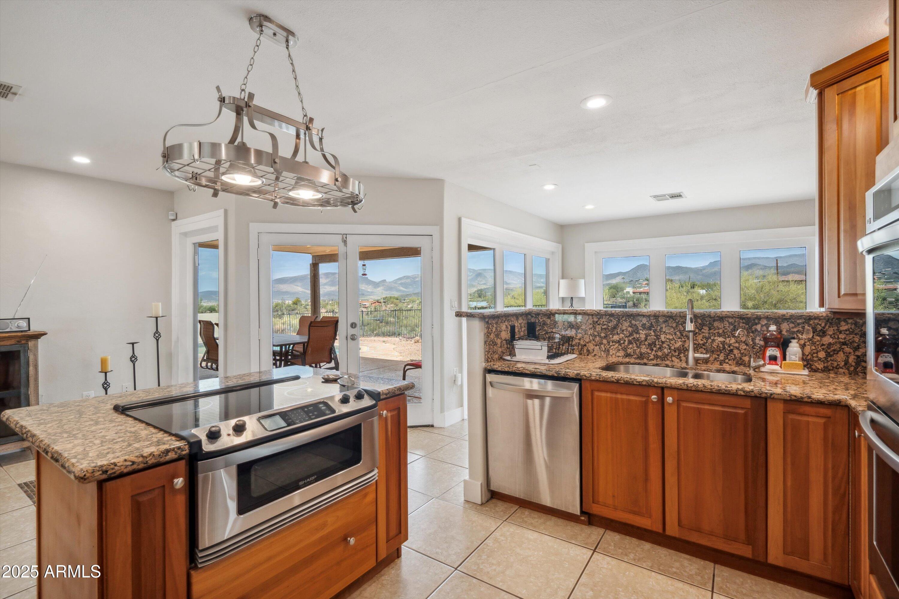 7080 East Arroyo Road Cave Creek, AZ 85331 - Photo 16 of 50 a kitchen with stainless steel appliances granite countertop a stove and a view of living room