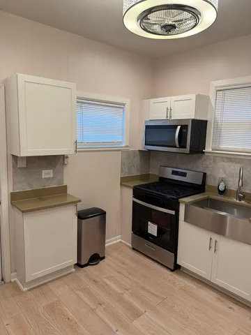 a kitchen with stainless steel appliances a stove a microwave and white cabinets