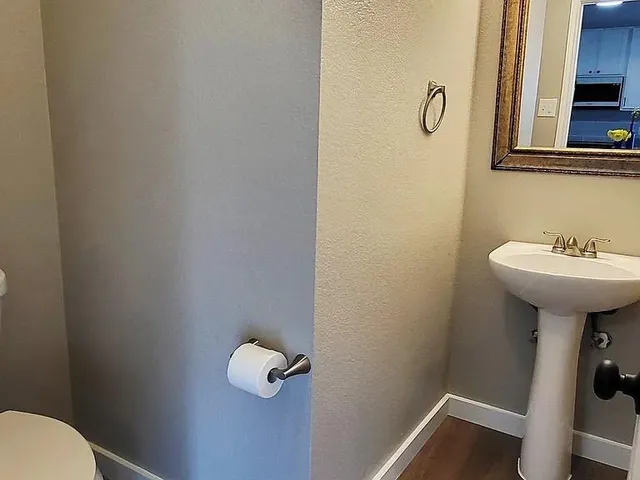a bathroom with a sink mirror and toilet