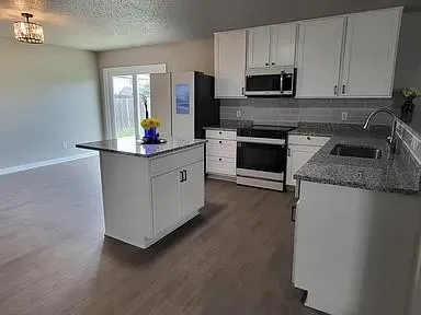 a kitchen with granite countertop a stove and a sink