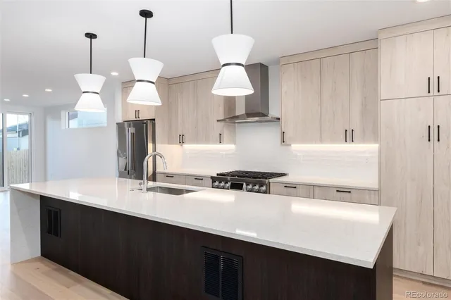 a kitchen with kitchen island a sink stainless steel appliances and cabinets