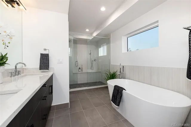 a bathroom with a double vanity sink a toilet and shower