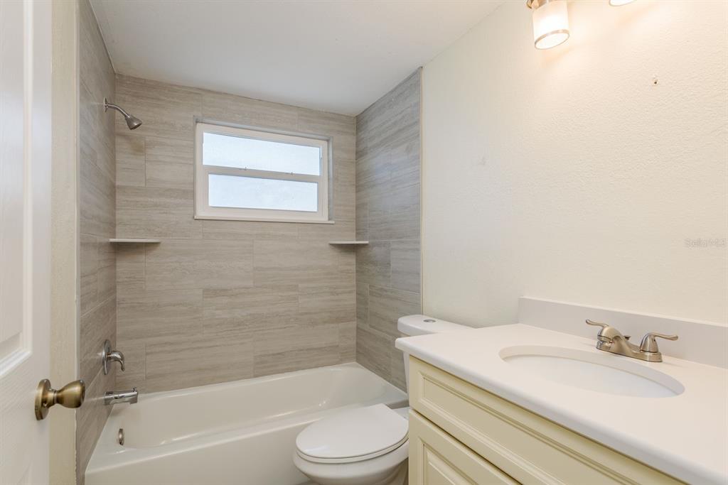 13816 Celida Avenue Hudson, FL 34667 - Photo 20 of 42 a bathroom with a granite countertop toilet sink and a bathtub