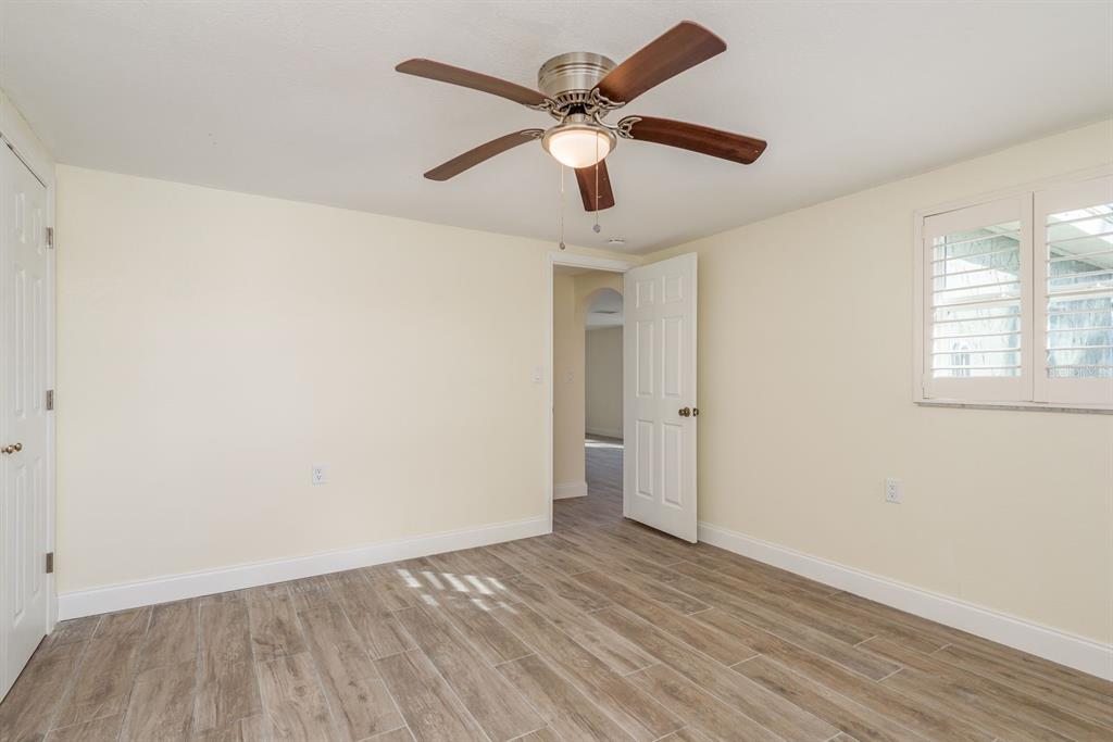 13816 Celida Avenue Hudson, FL 34667 - Photo 22 of 42 an empty room with wooden floor ceiling fan and windows
