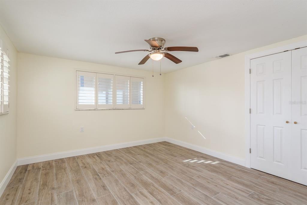 13816 Celida Avenue Hudson, FL 34667 - Photo 23 of 42 a view of empty room with wooden floor and fan
