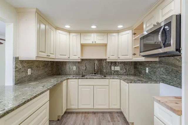 a kitchen with stainless steel appliances granite countertop a sink and a stove top oven