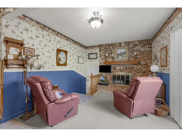 a living room with furniture a rug and white walls