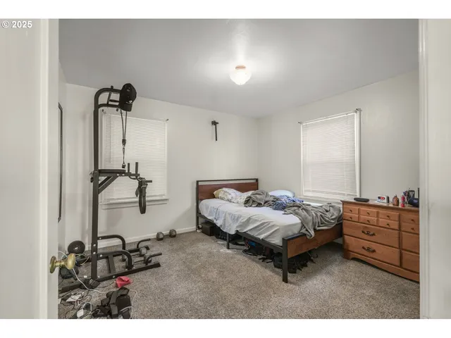 a spacious bedroom with a bed a dresser and a window