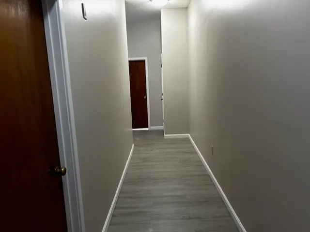 a view of a hallway with wooden floor