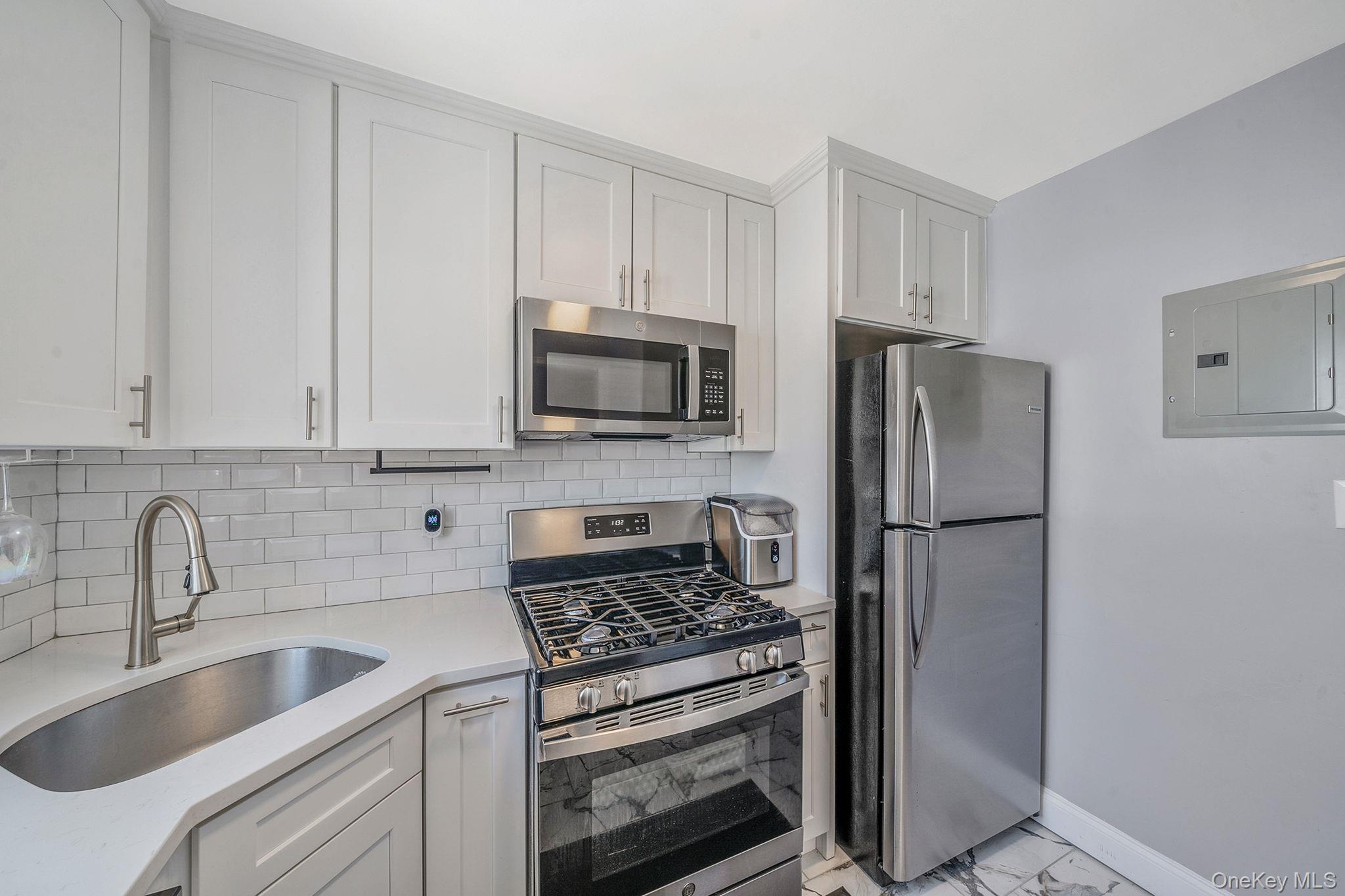 224-24 Manor Road, Unit UPPR Queens, NY 11427 - Photo 16 of 25 a kitchen with refrigerator a stove a sink and cabinets