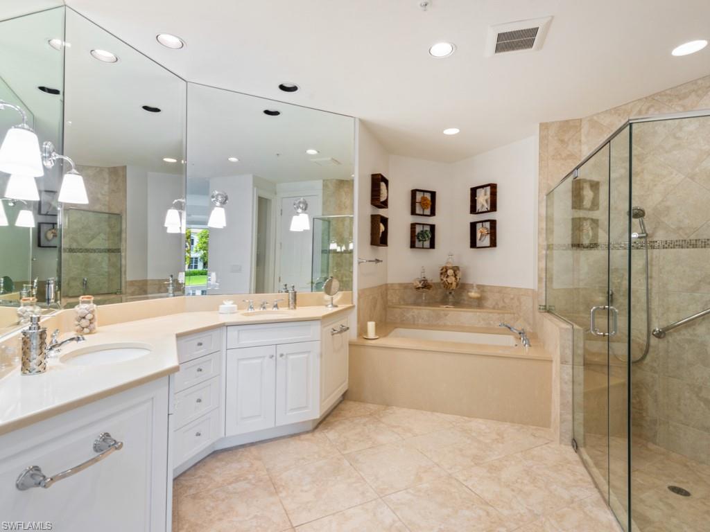 166 Colonade Circle Naples, FL 34103 - Photo 12 of 27 a bathroom with a bathtub shower sink vanity and mirror