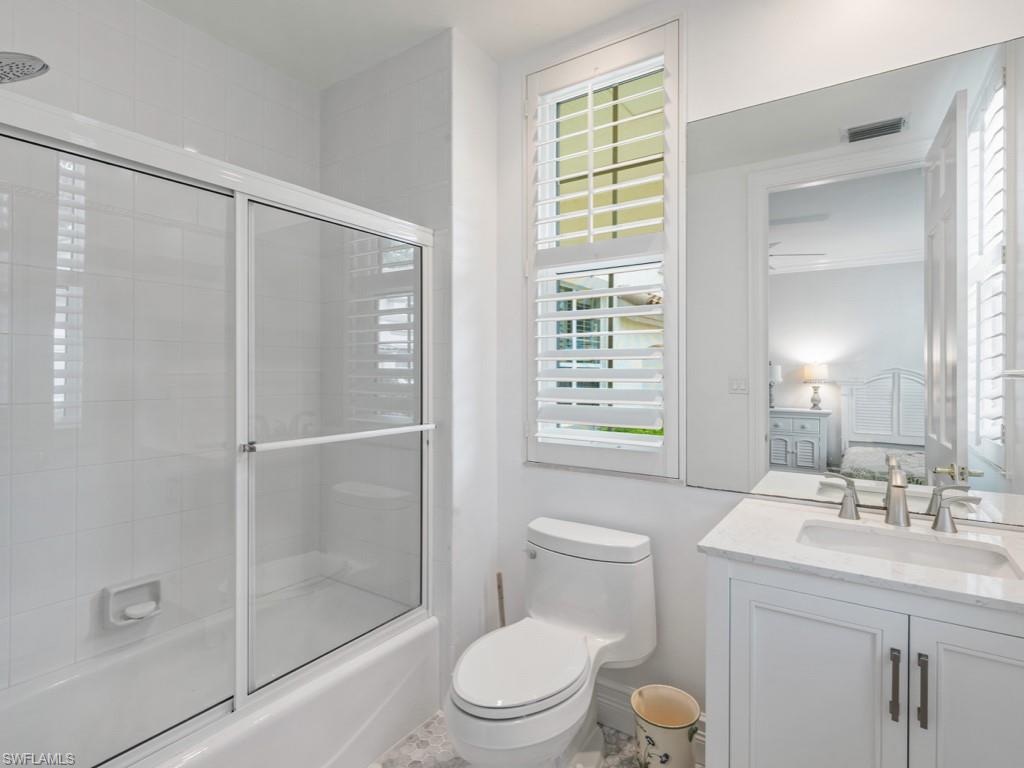 166 Colonade Circle Naples, FL 34103 - Photo 14 of 27 a bathroom with a toilet a sink a shower and a mirror