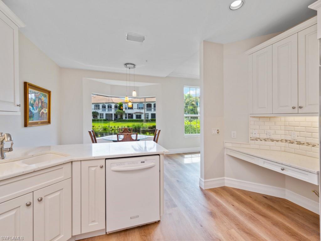 166 Colonade Circle Naples, FL 34103 - Photo 3 of 27 a kitchen with white cabinets and sink
