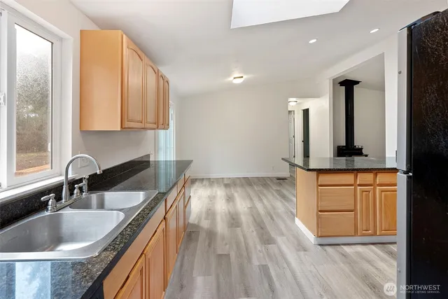 a kitchen with granite countertop a sink and cabinets
