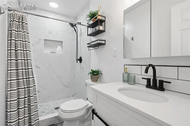 a bathroom with a granite countertop sink toilet and shower