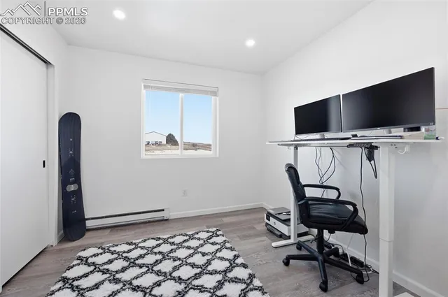a view of a workspace with furniture and a window