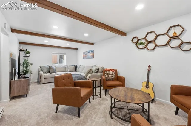 a living room with furniture a rug and a wall painting