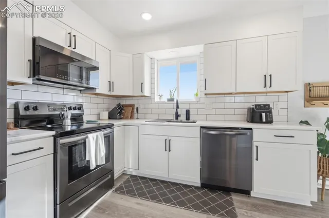 a kitchen with stainless steel appliances granite countertop a stove a sink and a microwave