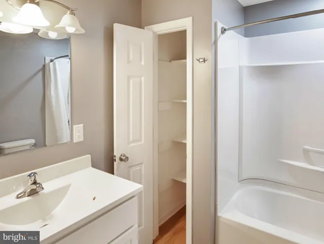 a view of an empty room with cabinet and a ceiling fan