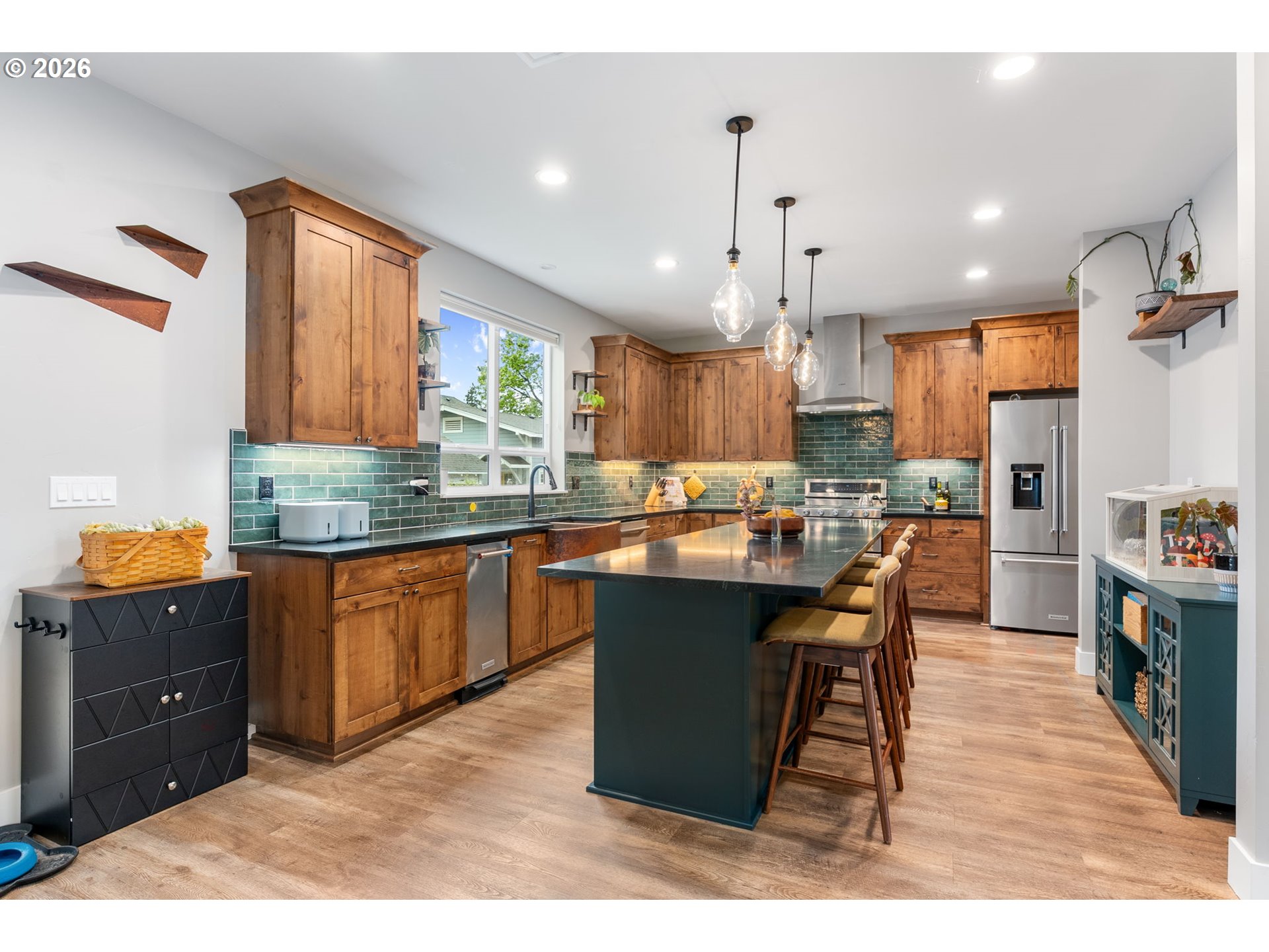 1114 9th Street Hood River, OR 97031 - Photo 3 of 48 a kitchen with stainless steel appliances kitchen island granite countertop a table chairs and a refrigerator