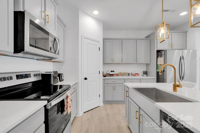 a kitchen with stainless steel appliances a sink stove and cabinets