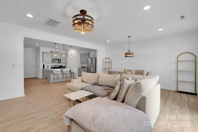 a living room with lots of furniture and kitchen view