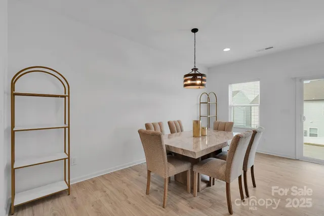 a dining room with furniture a chandelier and wooden floor