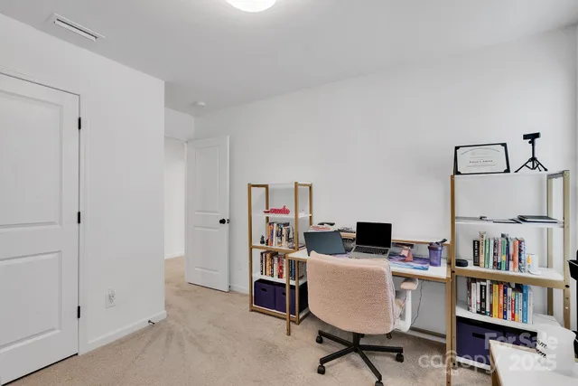 a view of a workspace with furniture and a book shelf