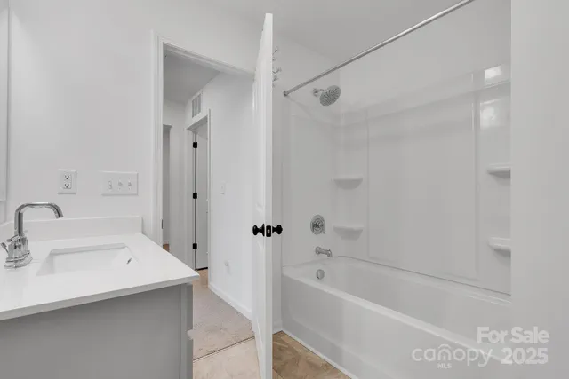 a bathroom with a tub shower sink vanity and a mirror