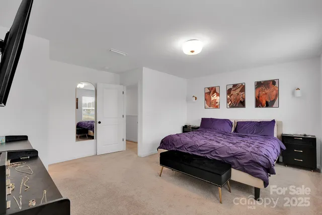 a spacious bedroom with a bed and a view of bathroom
