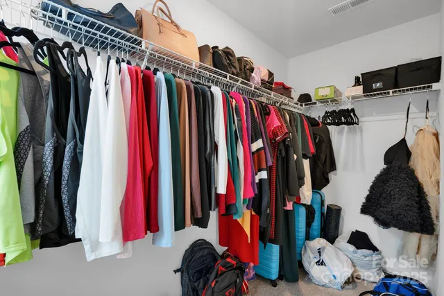 a view of walk in closet with clothes and shoes