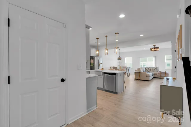 a open kitchen with stainless steel appliances refrigerator stove and wooden floor