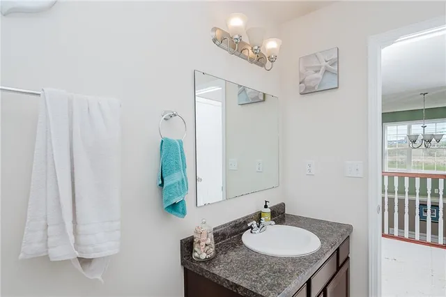 a en suite bathroom with a granite countertop sink and a mirror