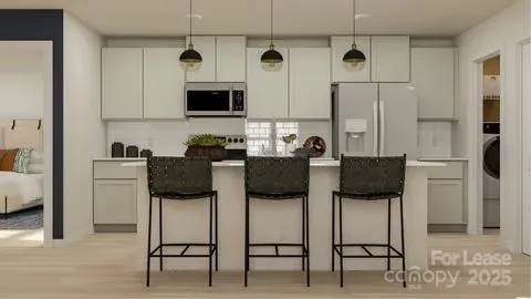 a kitchen with stainless steel appliances kitchen island granite countertop a table and chairs in it