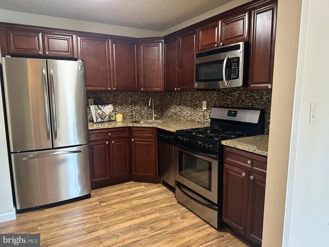 a view of a dining room with furniture wooden floor and a refrigerator