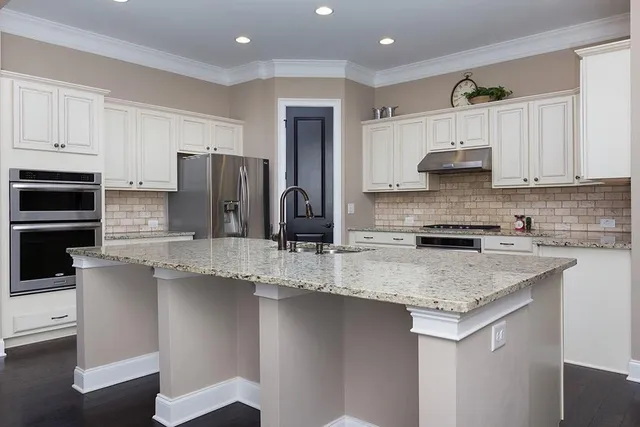a kitchen with stainless steel appliances granite countertop a sink stove and refrigerator