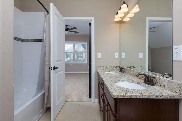 a bathroom with a granite countertop sink a mirror and a shower