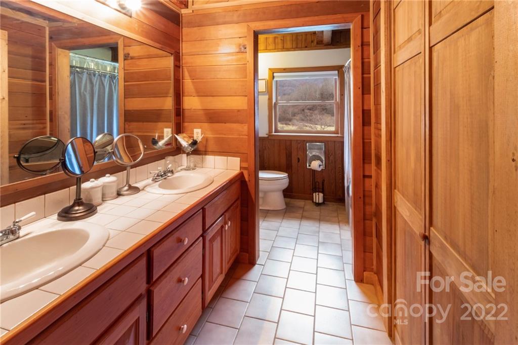 624 James Chapel Road Clyde, NC 28721 - Photo 15 of 46 a bathroom with a double vanity sink and a mirror