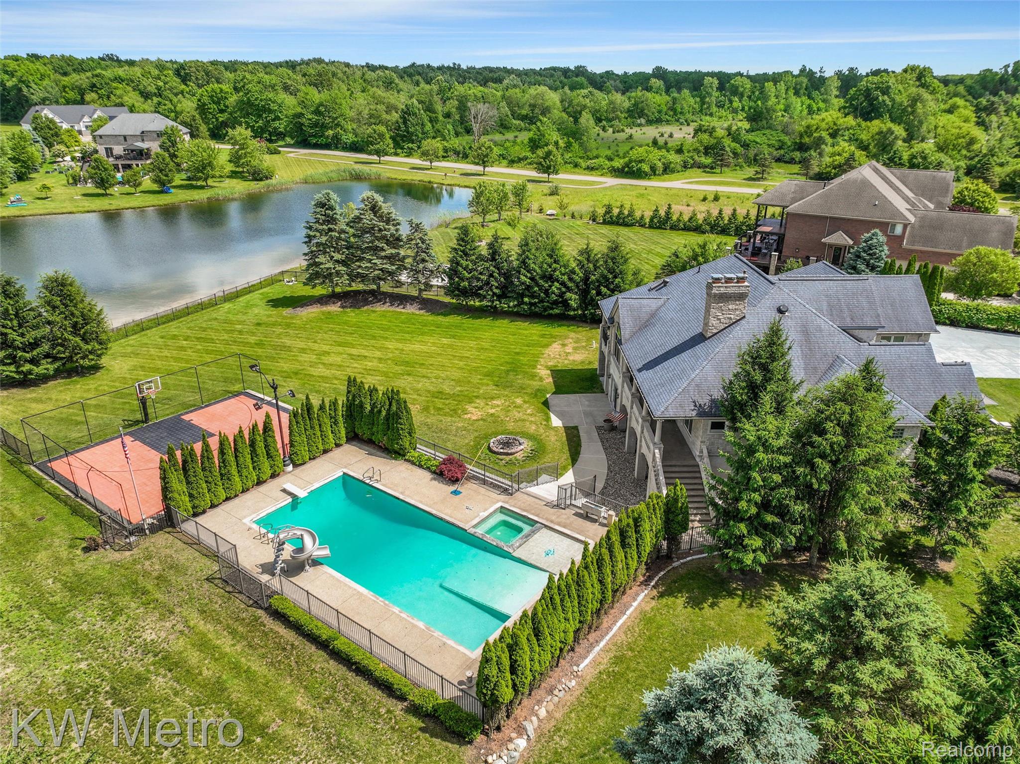 65884 Windrose Court Ray, MI 48096 - Photo 21 of 82 Expansive property featuring a large in-ground swimming pool with an attached spa, a fenced sports court, and substantial green space