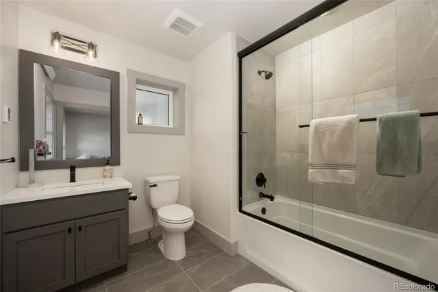 a bathroom with a double vanity sink toilet and shower