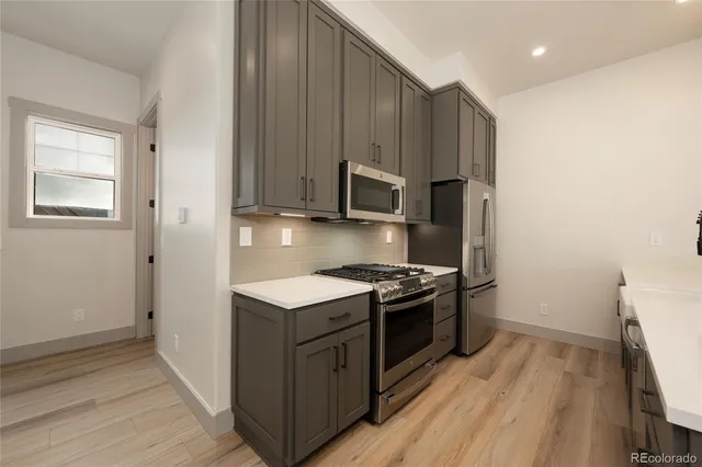 a kitchen with stainless steel appliances granite countertop a stove a sink and a refrigerator