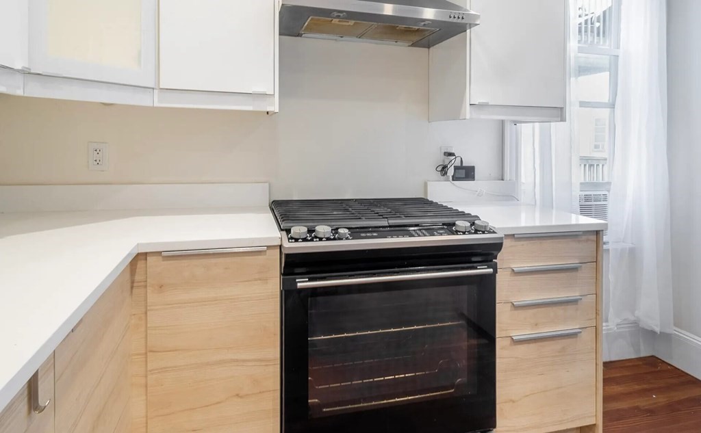 a stove top oven sitting inside of a kitchen