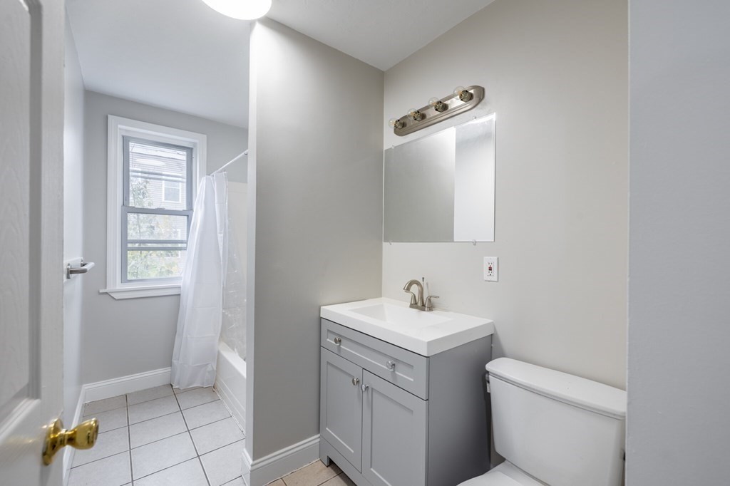 17 Cawfield Street, Unit 2 Boston, MA 02125 - Photo 11 of 14 a bathroom with a toilet sink and mirror