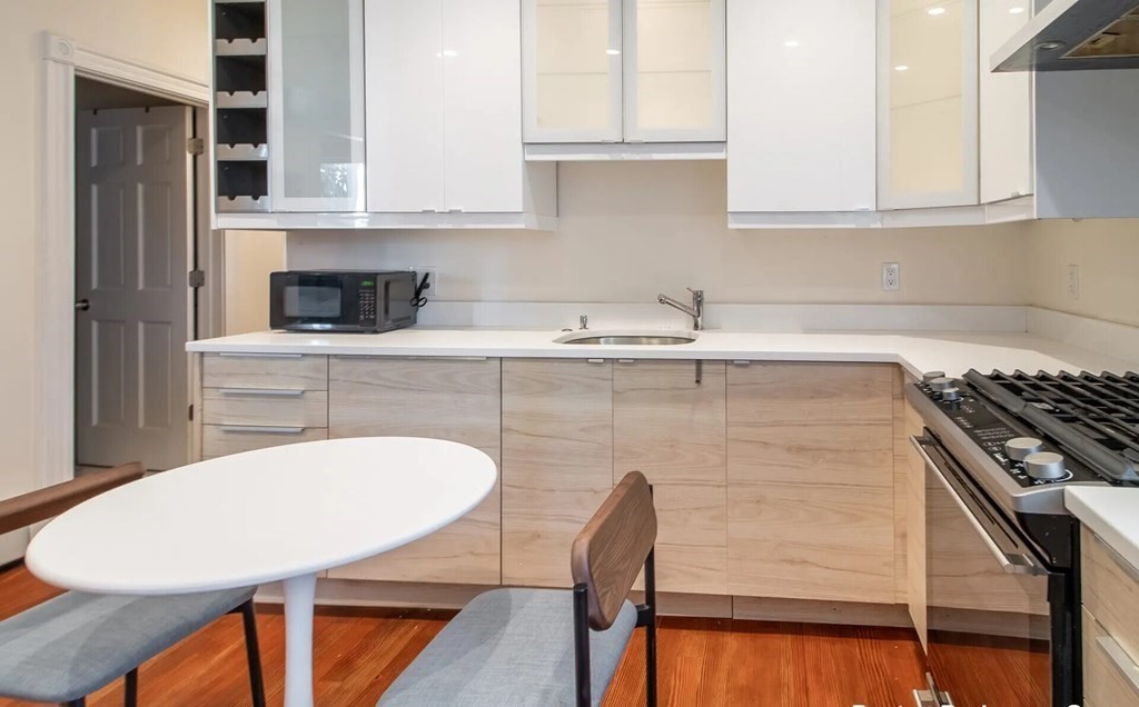 17 Cawfield Street, Unit 2 Boston, MA 02125 - Photo 2 of 14 a kitchen with a sink cabinets and a stove top oven