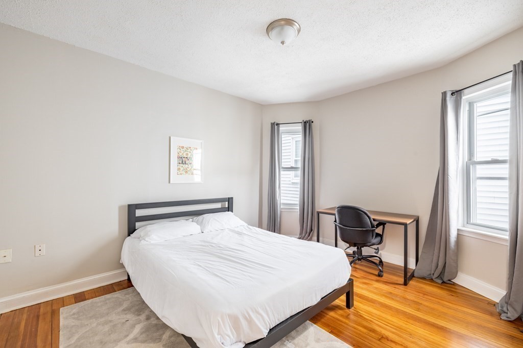 17 Cawfield Street, Unit 2 Boston, MA 02125 - Photo 3 of 14 a bedroom with a bed a table and chair