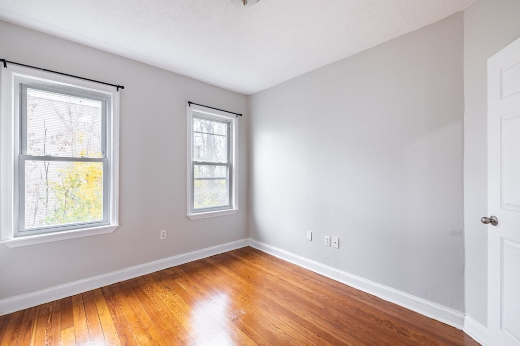 17 Cawfield Street, Unit 2 Boston, MA 02125 - Photo 7 of 14 a view of an empty room with wooden floor and a window
