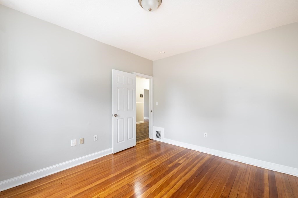 17 Cawfield Street, Unit 2 Boston, MA 02125 - Photo 10 of 14 a view of an empty room with wooden floor and cabinet