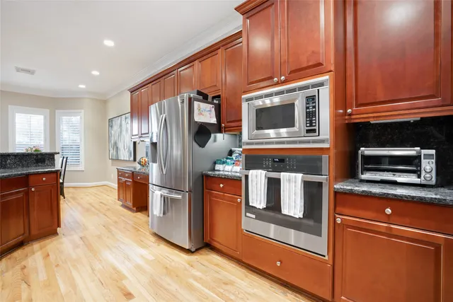 a kitchen with stainless steel appliances granite countertop a refrigerator stove and sink