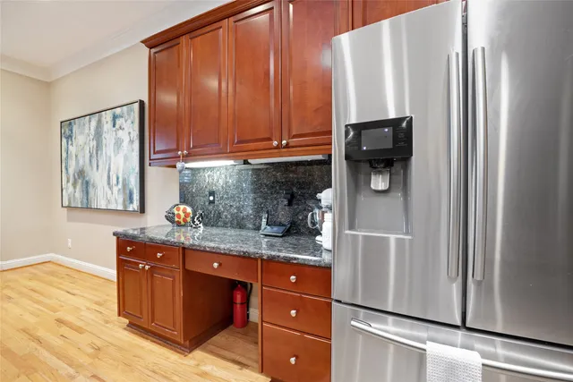 a kitchen with stainless steel appliances granite countertop a refrigerator and a stove top oven